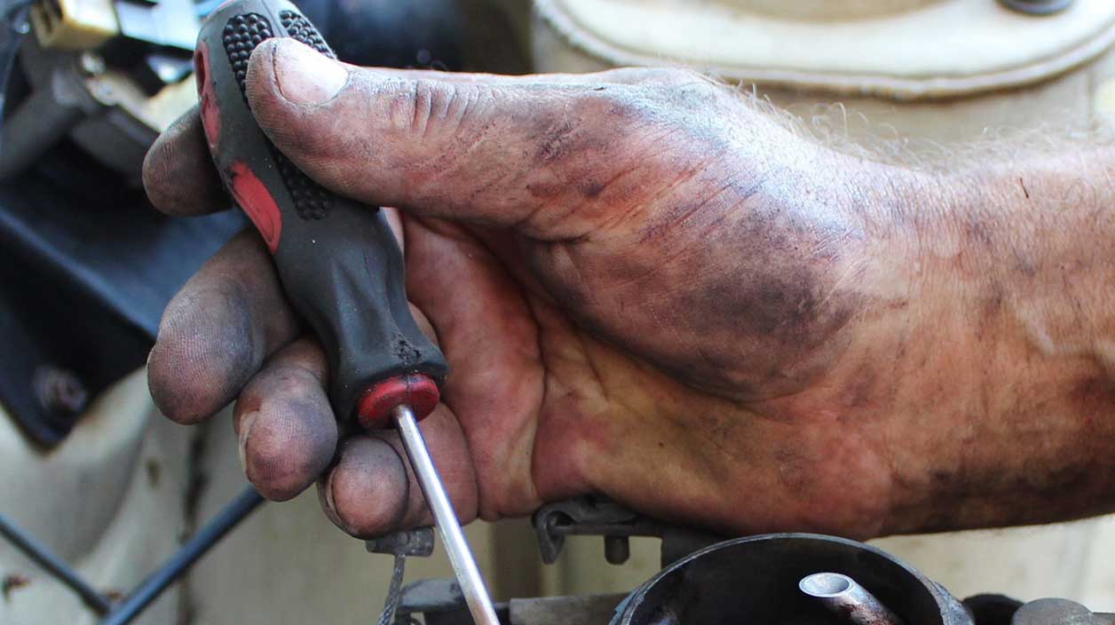 une main de mécanicien qui s'occupe du moteur d'une voiture