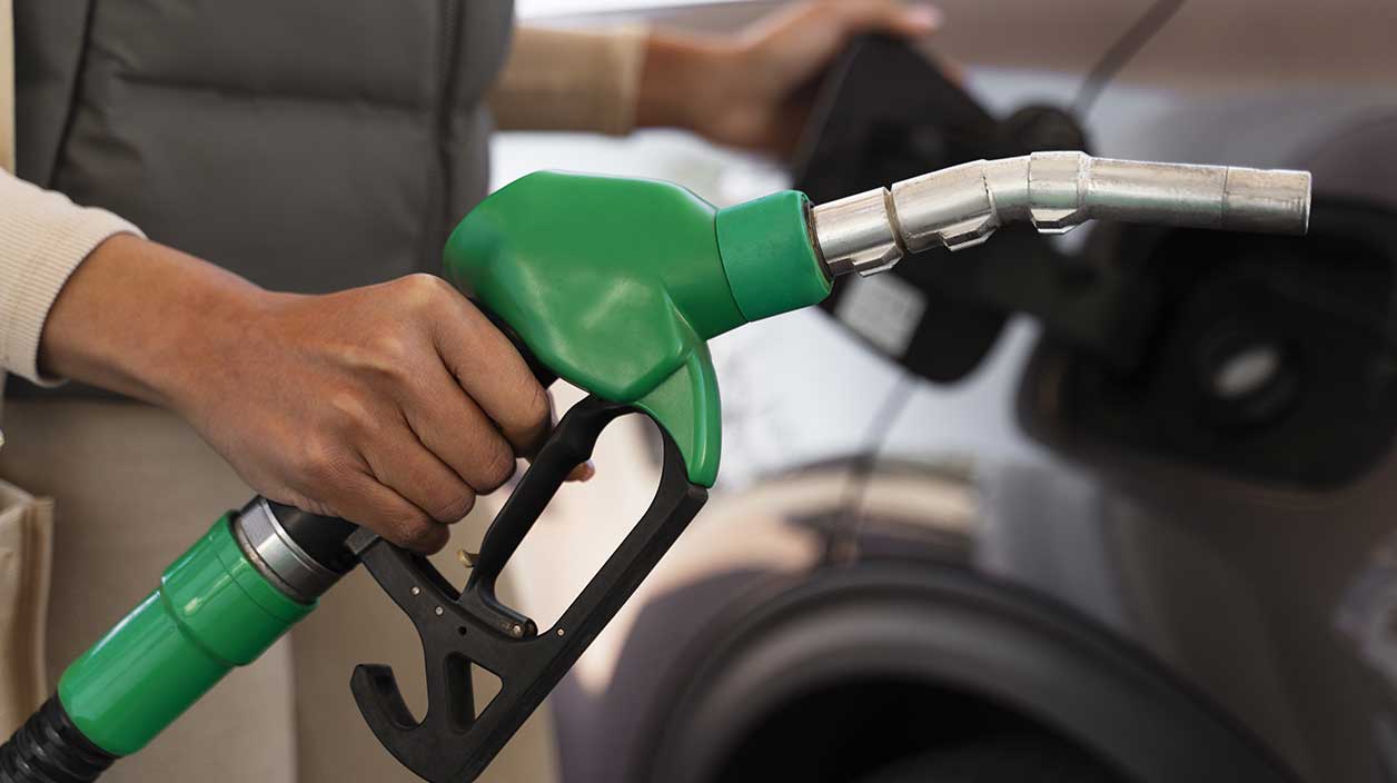 Quelqu'un qui tient une pompe pour remettre de l'essence dans une voiture