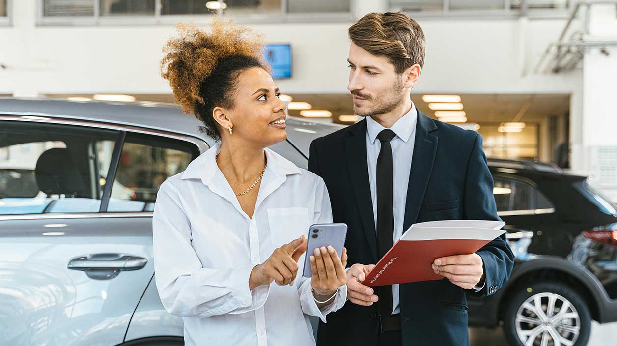 Une cliente qui demande conseil à u vendeur ou concessionnaire automobile