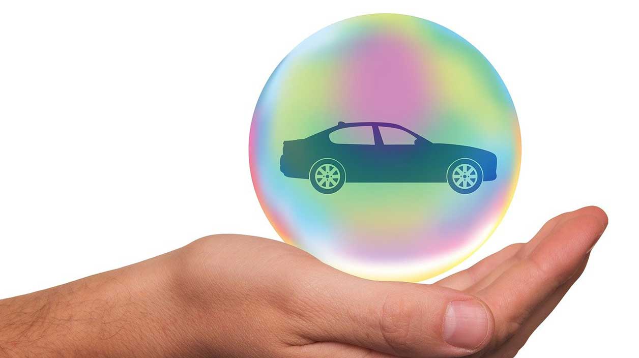 visuel d'une main qui protège une voiture comme une assurance