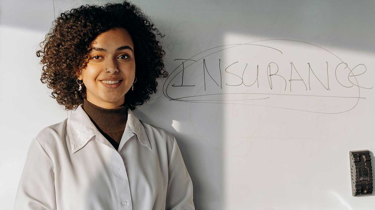 jeune femme devant un tableau avec marqué "insurance"