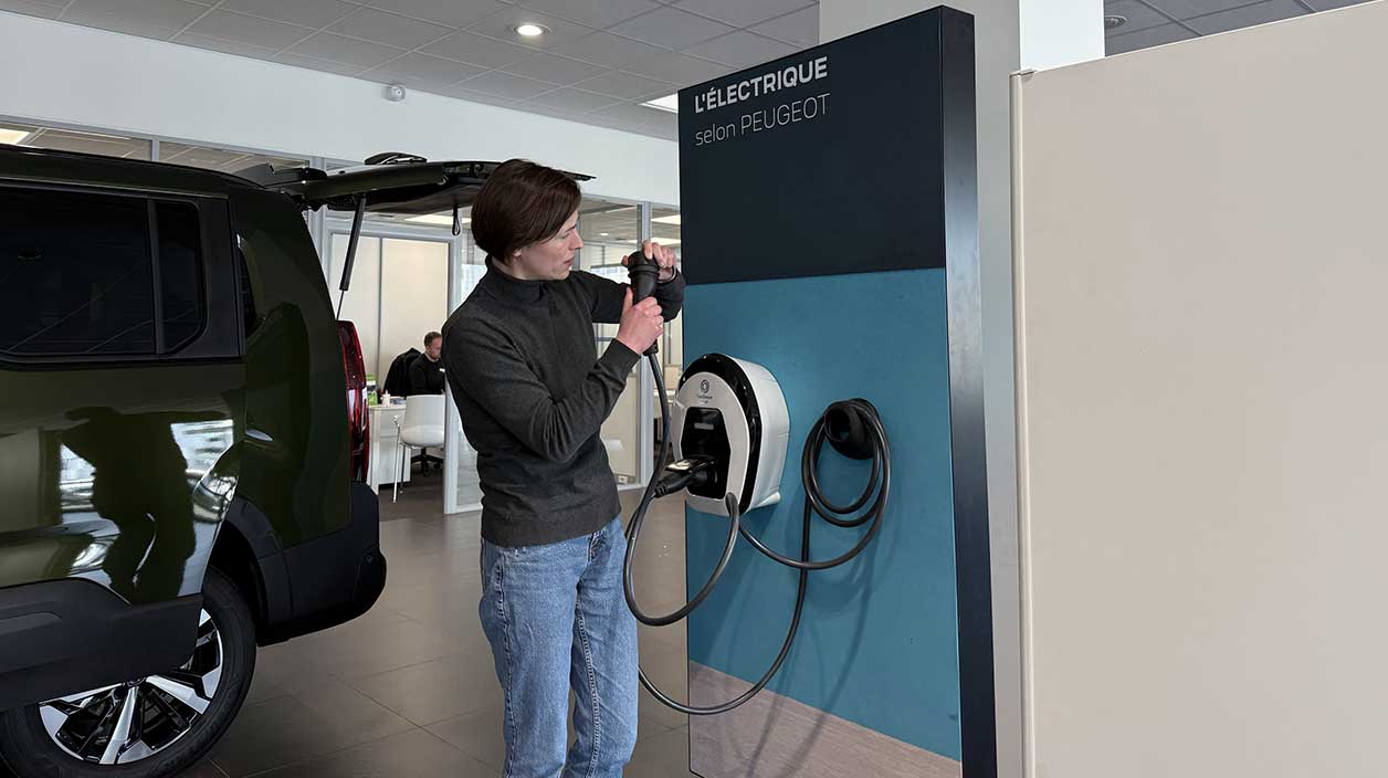 femme qui ne comprend ce qu'est une prise de recharge électrique 